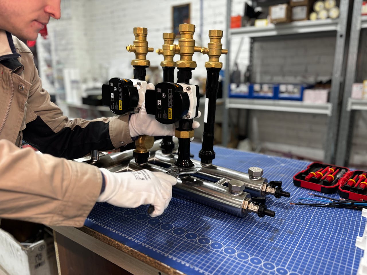 Engineer assembling a piping system for industrial heating, featuring valves and control units.